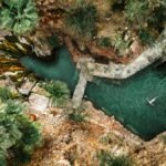 Aerial view of natural hot spring pools in a rocky canyon with mineral-green water at Castle Hot Springs, Morristown