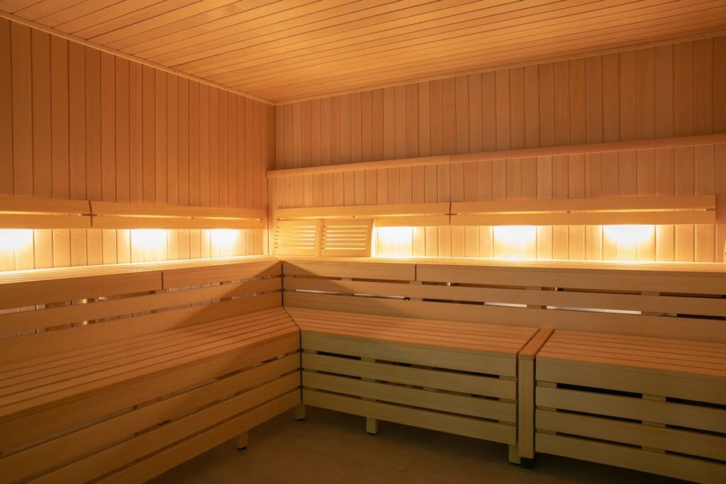 Cedar-panelled sauna interior with tiered wooden benches and warm backlighting at CIVANA Wellness Resort and Spa, Carefree