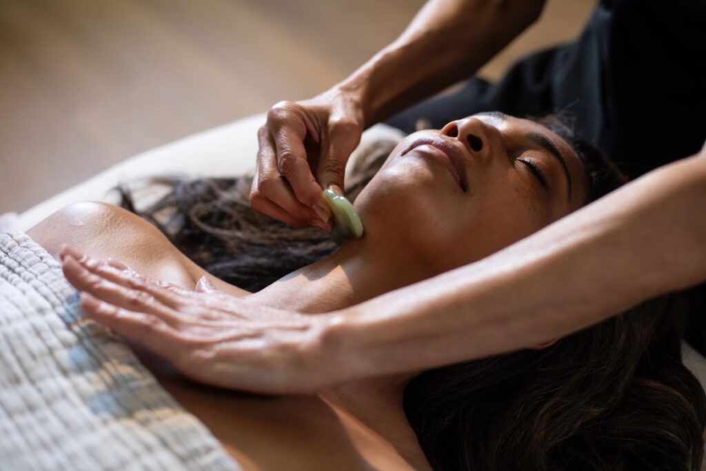 Therapist performing a jade gua sha facial treatment on a guest at CIVANA Wellness Resort and Spa, Carefree