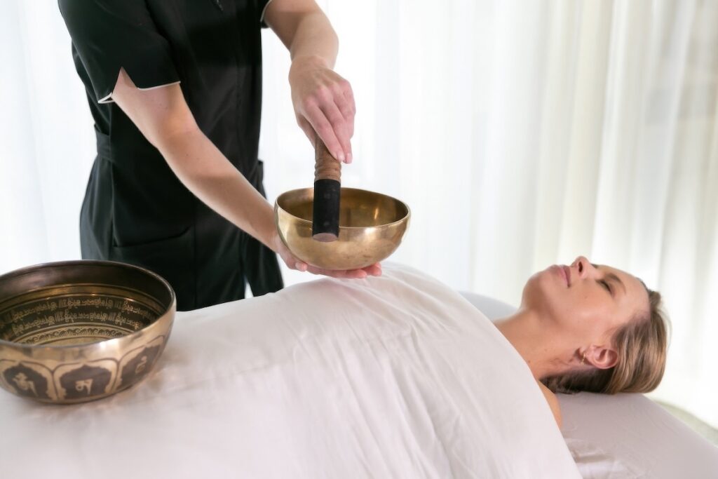 Therapist performing a Tibetan singing bowl sound healing session on a guest at CIVANA Wellness Resort and Spa, Carefree