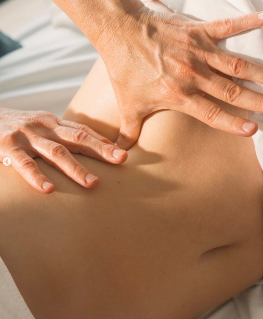 Therapist hands performing deep tissue back massage on treatment table at The Global Ambassador, Phoenix