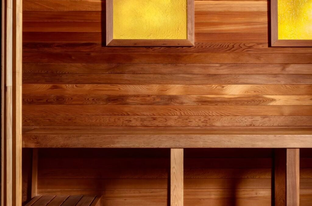 Cedar-lined sauna interior with tiered bench and amber backlit wall panels at the spa at Grand Hyatt Scottsdale Resort