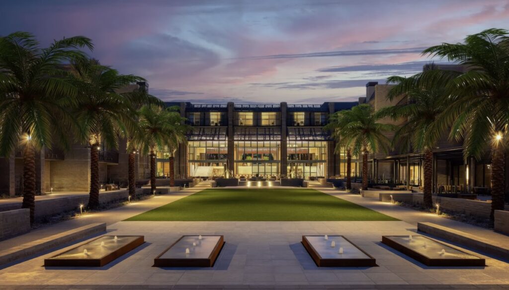 Main building and palm-lined courtyard with rectangular water features and lawn at twilight at Grand Hyatt Scottsdale Resort