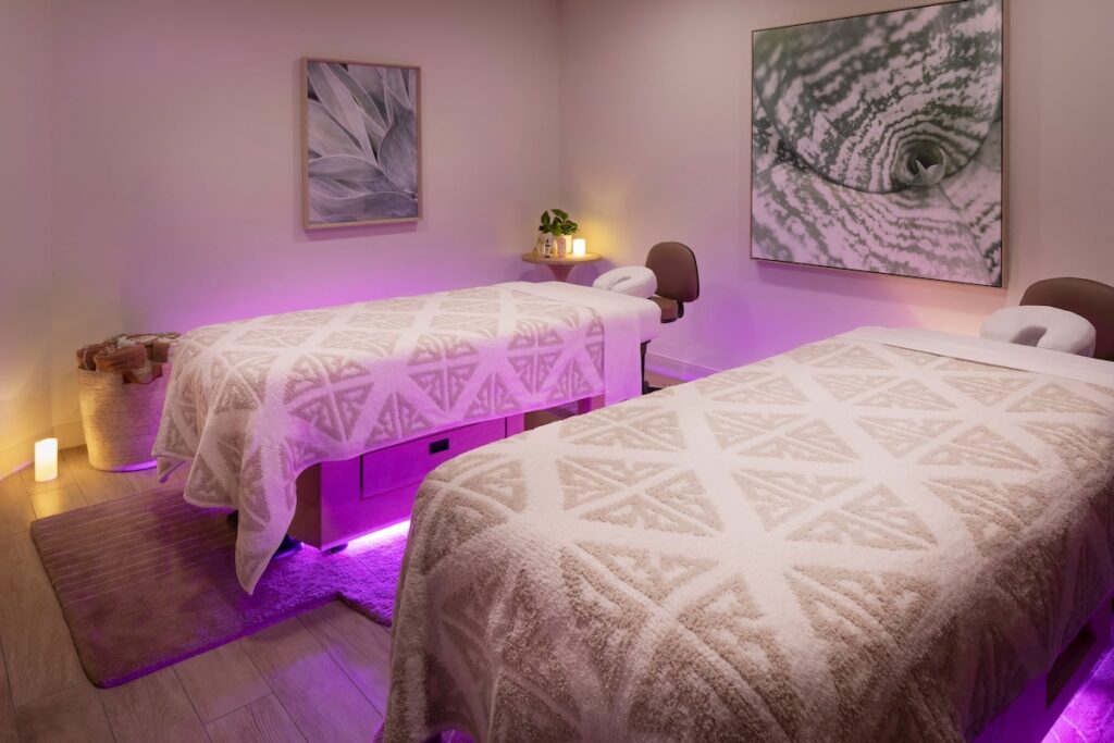Spa couples treatment room with dual massage tables and pink ambient lighting at The Scottsdale Resort and Spa