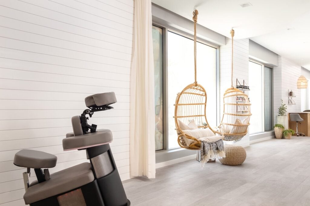 AWAY Spa treatment area with massage chair, rattan hanging seats, and floor-to-ceiling windows at W Scottsdale, Arizona