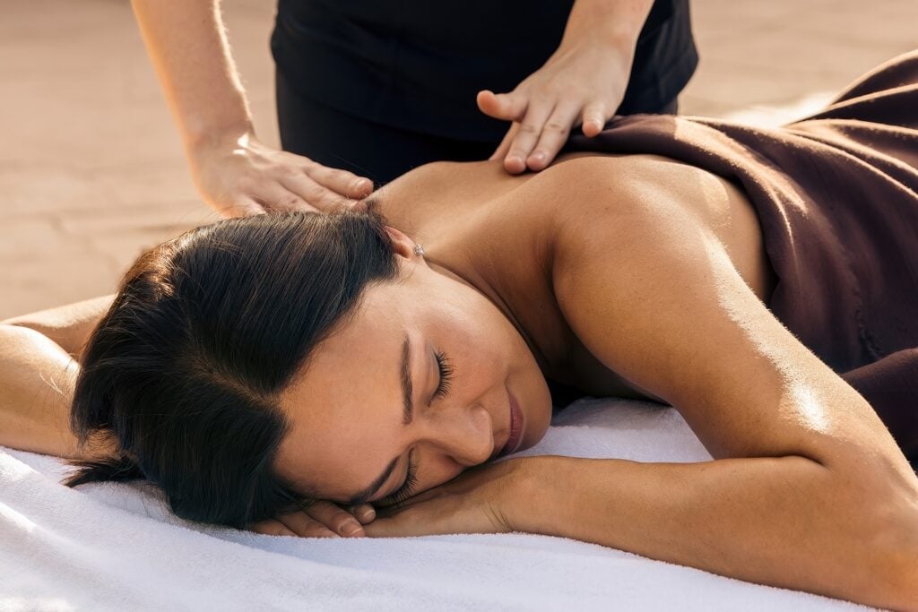 Therapist performing back massage on guest outdoors at Canyon Ranch Tucson, Tucson