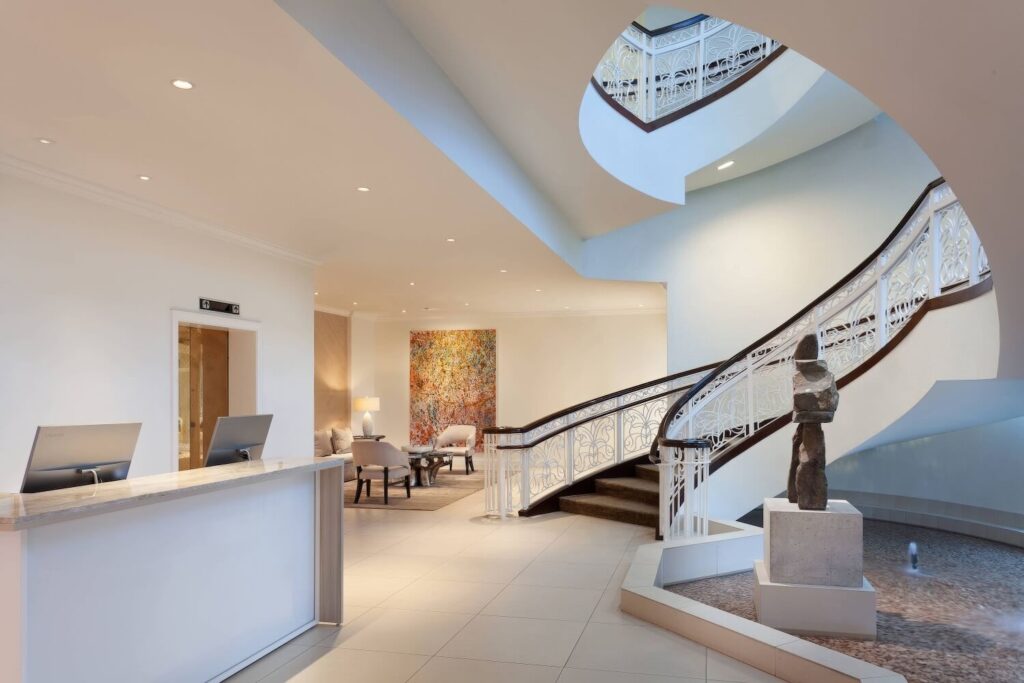 Spa reception area with ornate white iron spiral staircase, stone sculpture and abstract canvas, JW Marriott Turnberry Resort & Spa, Miami