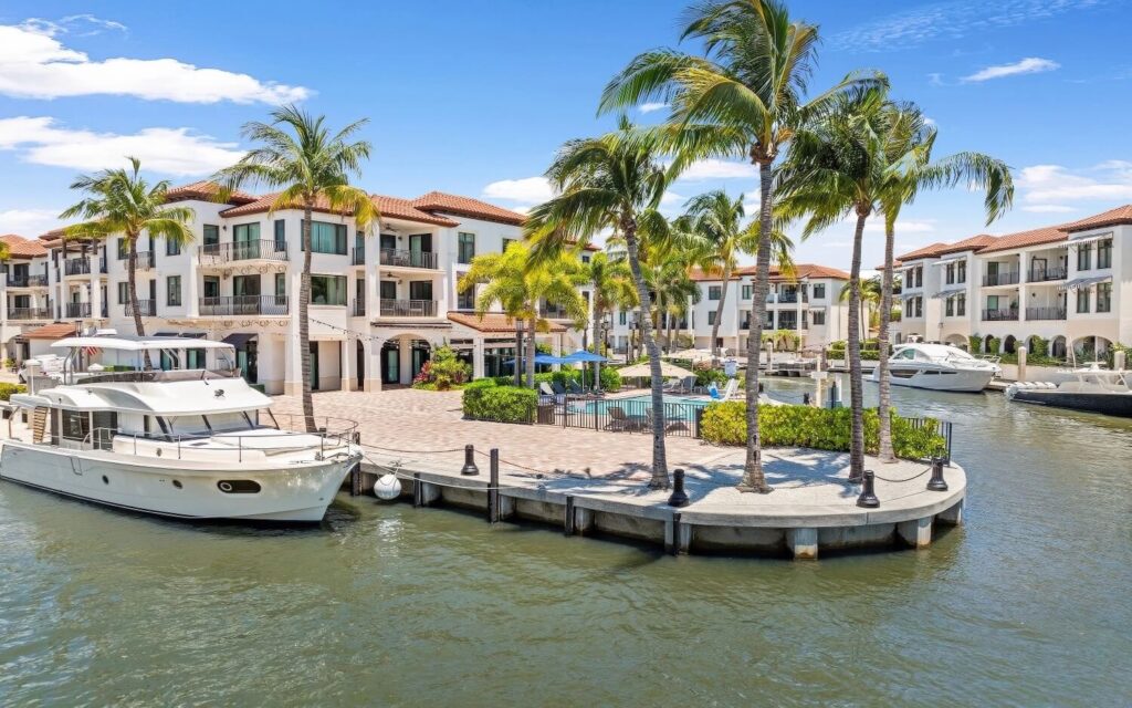 Waterfront pool area framed by palm trees and docked yacht at Naples Bay Resort & Marina, Naples, Florida.