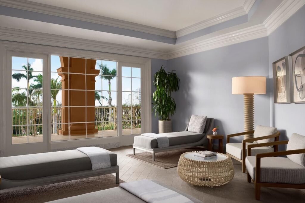 Spa relaxation lounge with grey chaise loungers and palm-view windows at The Ritz-Carlton, Naples, Naples Florida