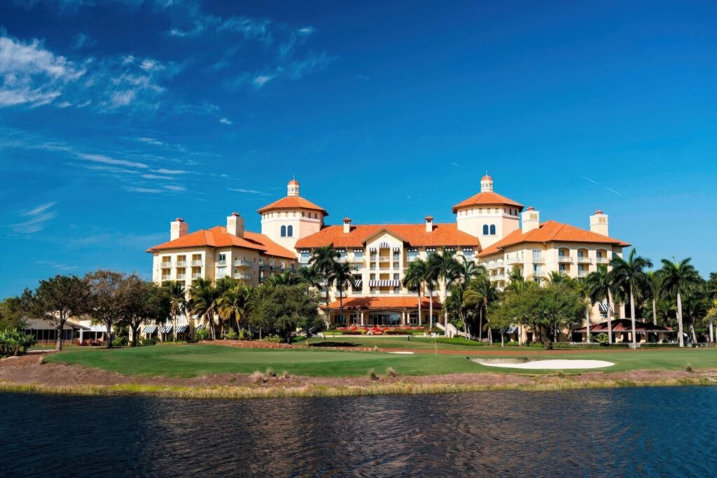 Mediterranean-style resort exterior viewed across golf course lake at The Ritz-Carlton Naples, Tiburon, Naples Florida