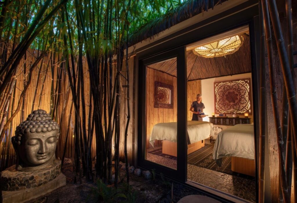 Spa massage suite with therapist preparing treatment beside bamboo grove at Bungalows Key Largo, Florida Keys