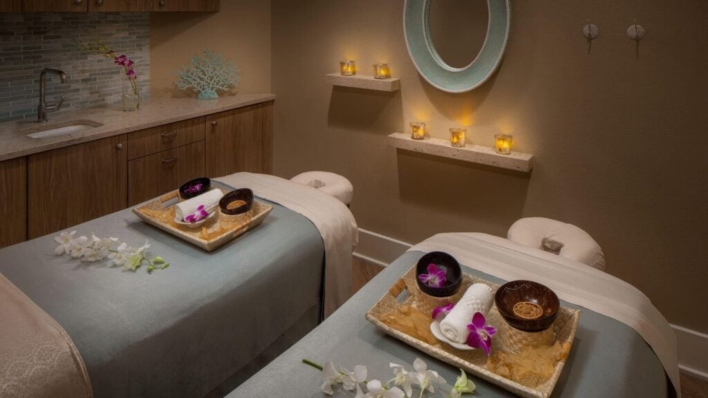 Couples massage room with candle-lit shelves and orchid styling at Jala Spa, Hyatt Centric Key West Resort & Spa, Key West