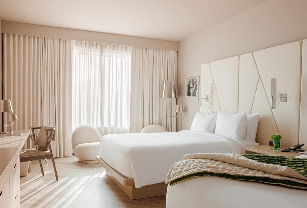Bright king room with sculptural white egg chair and angular padded headboard at Ette Hotel Orlando, Florida