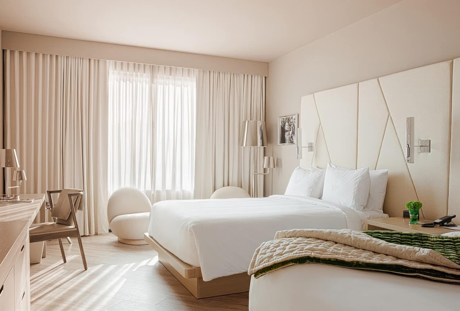 Bright king room with sculptural white egg chair and angular padded headboard at Ette Hotel Orlando, Florida