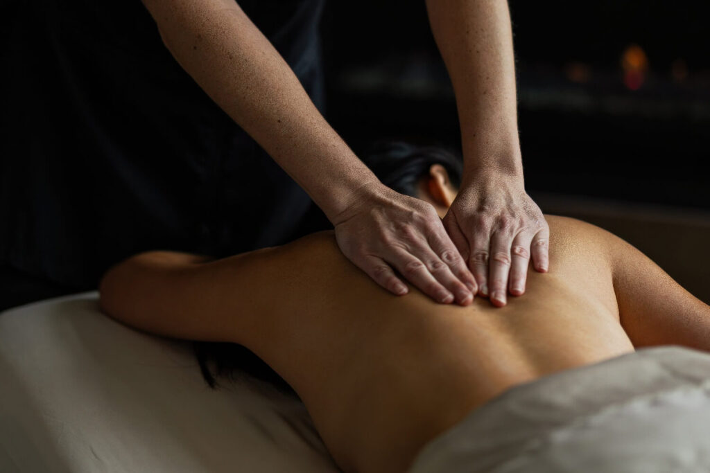 Therapist giving a back massage by candlelight in a treatment room at Bardessono Hotel & Spa, Yountville, Napa Valley