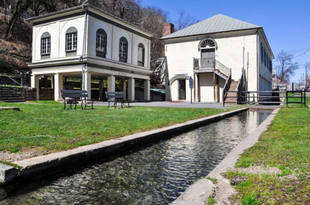 Historic 19th-century bathhouse buildings beside the spring channel at Berkeley Springs State Park, West Virginia