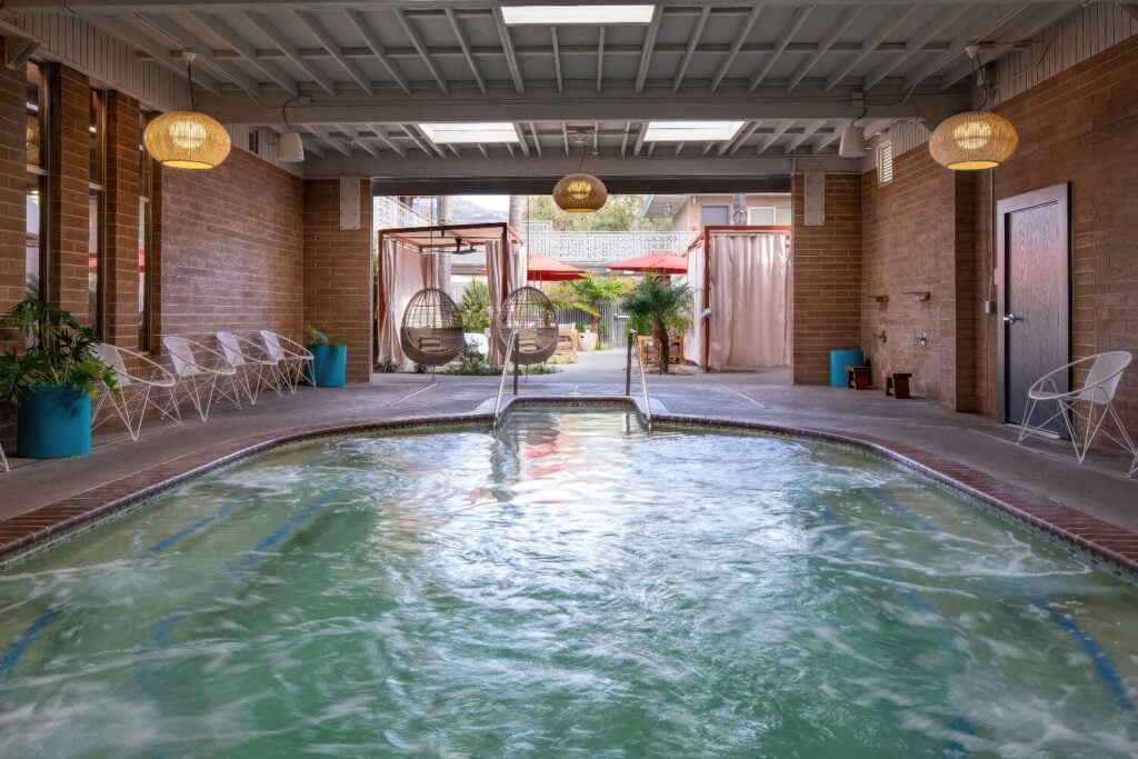 Indoor geothermal mineral pool with brick walls and rattan pendant lights, Dr. Wilkinson's Backyard Resort, Calistoga