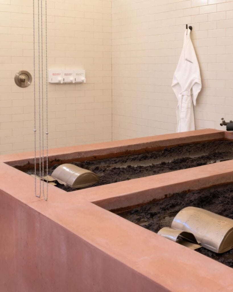 Terracotta mud-bath tubs with metal headrests and a robe in a tiled treatment room, Dr. Wilkinson's Backyard Resort, Calistoga