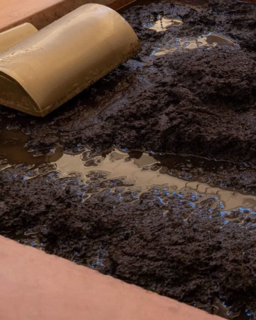 Close-up of the signature volcanic-ash mud bath with a wooden headrest, Dr. Wilkinson's Backyard Resort, Calistoga