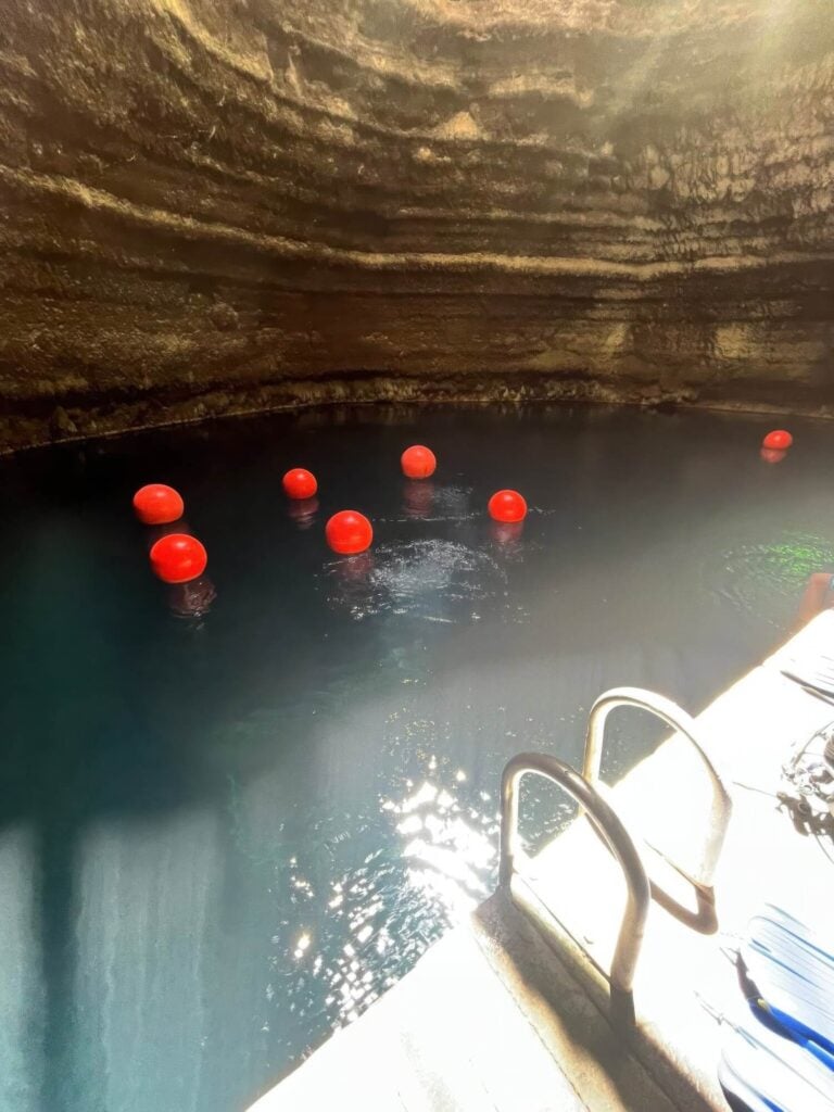 Red marker buoys floating on the geothermal pool inside the domed Homestead Crater, Utah