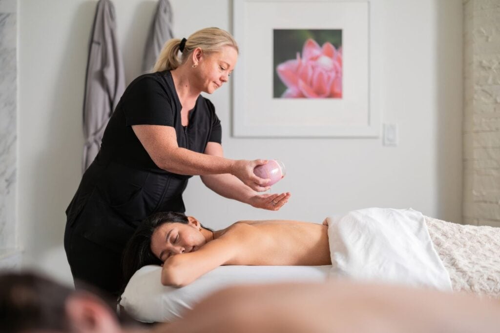 Therapist warming oil for a back massage on a guest in the spa at Hotel Yountville, Yountville