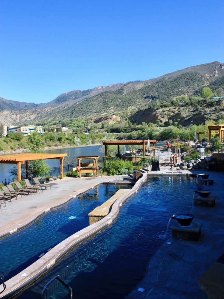 Landscaped stone soaking pools beside the Colorado River and mountains at Iron Mountain Hot Springs, Colorado