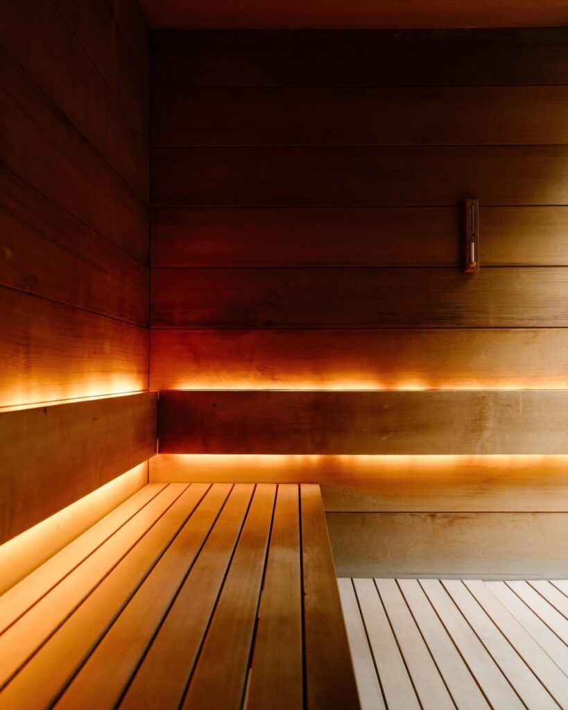 Cedar-lined sauna with backlit tiered benches and soft amber lighting at Meadowood Napa Valley, St. Helena, California