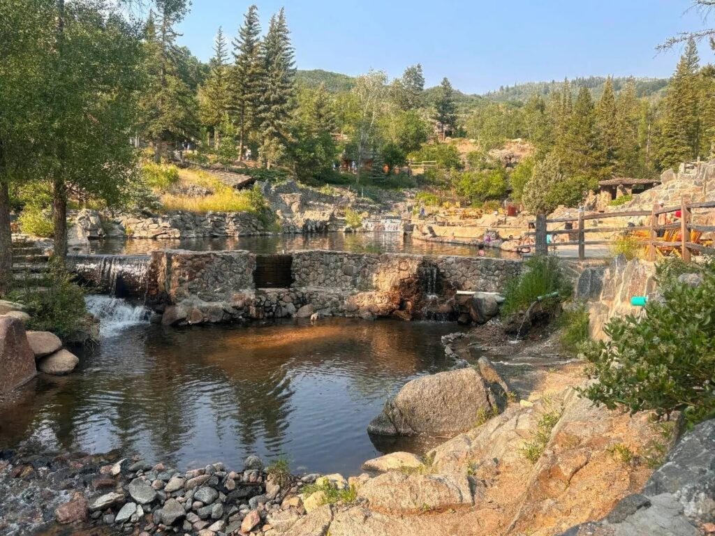Rustic stone-masonry hot pools beside a creek in the pines at Strawberry Park Hot Springs, Colorado