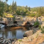 Rustic stone-masonry hot pools beside a creek in the pines at Strawberry Park Hot Springs, Colorado