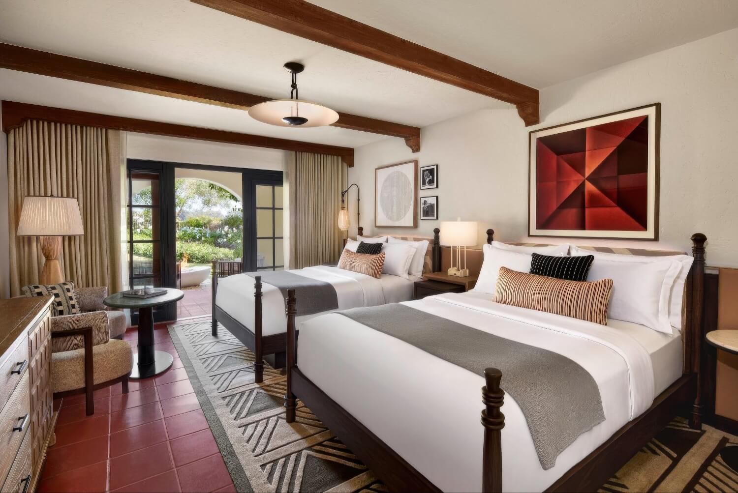 Fireside guest room with two queen beds, wood-beam ceiling and garden patio at The Ritz-Carlton Bacara, Santa Barbara