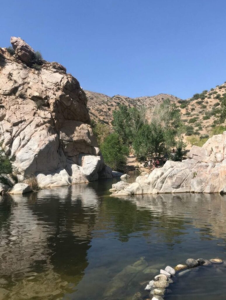 Rock-lined natural soaking pools beneath granite outcrops in the high-desert canyon at Deep Creek Hot Springs, California