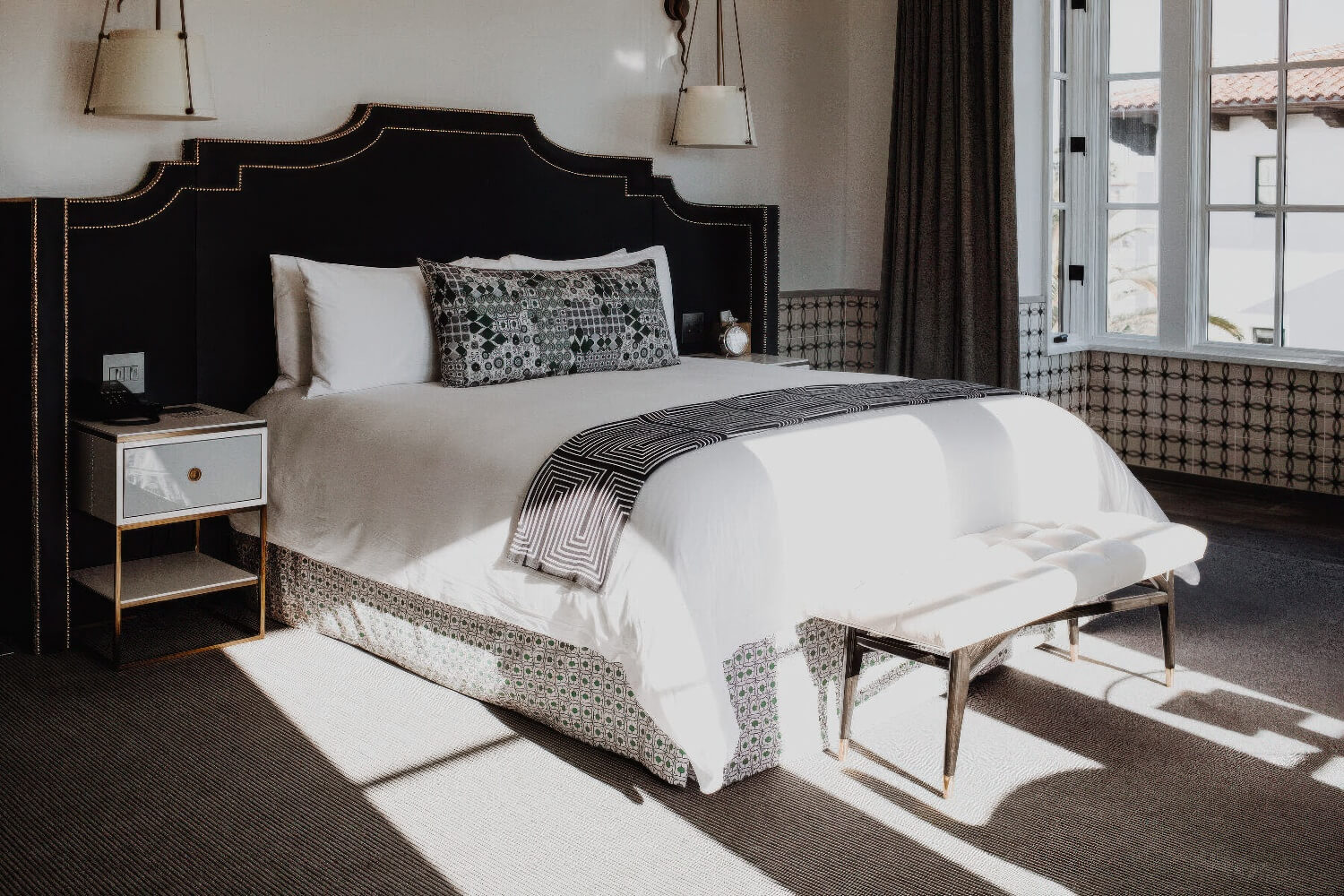 King guest room with a studded black headboard and patterned tile wainscot at Hotel Californian, Santa Barbara