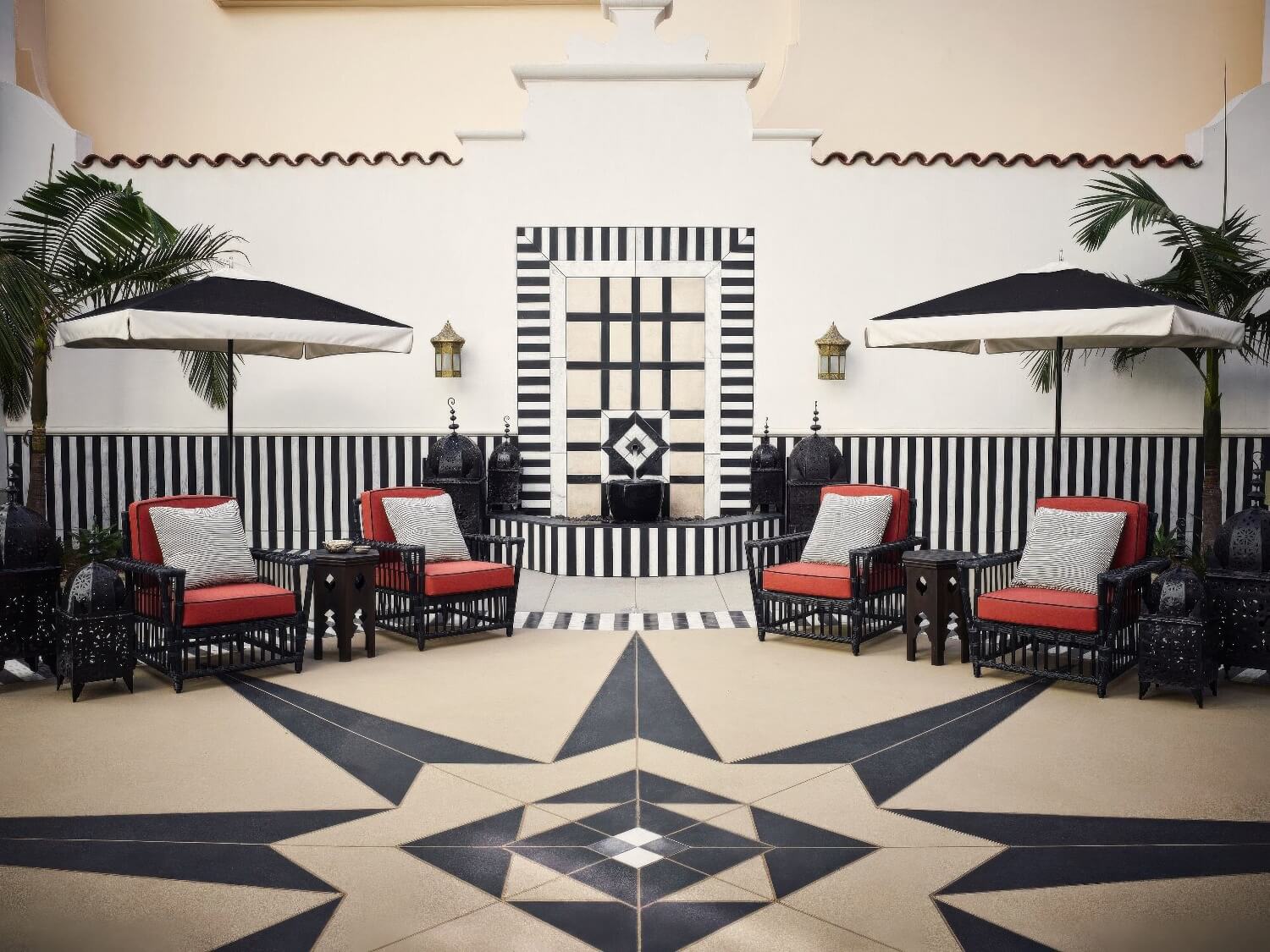 Moroccan courtyard with a striped tile fountain, compass-star floor and lantern seating at Hotel Californian, Santa Barbara