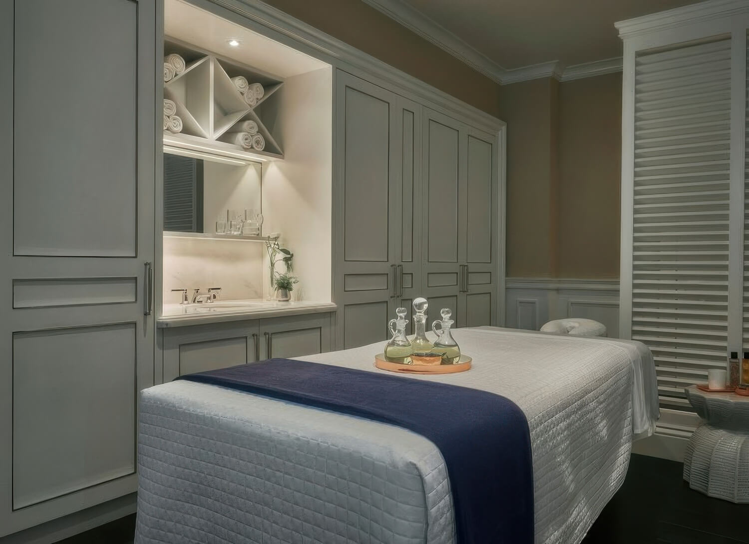 Sense Spa treatment room with a quilted table and oil decanters on a copper tray at Rosewood Miramar Beach, Montecito
