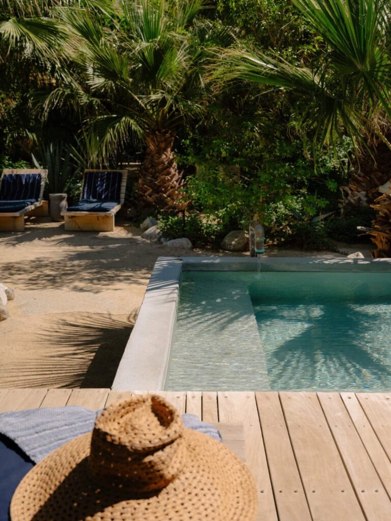 Concrete mineral soaking tub with a copper spout on a wood deck in the palm grove at Two Bunch Palms, Desert Hot Springs, California