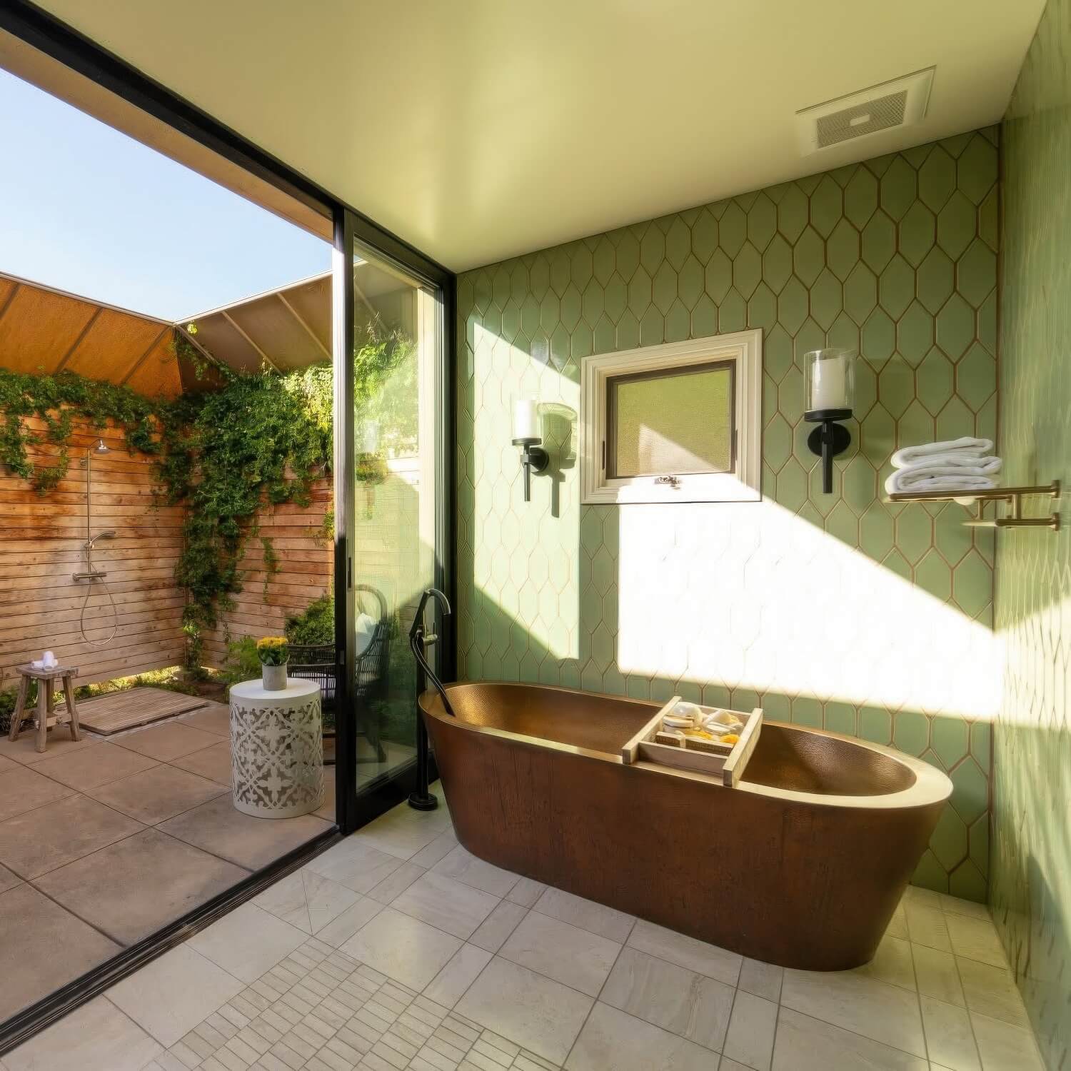 Copper soaking tub in a green-tiled bathroom opening to a private outdoor shower at Bernardus Lodge and Spa, Carmel Valley