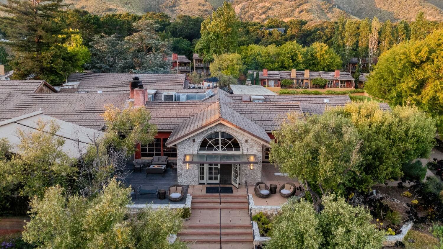 Aerial of the main lodge entrance and terrace with Santa Lucia foothills behind at Bernardus Lodge and Spa, Carmel Valley