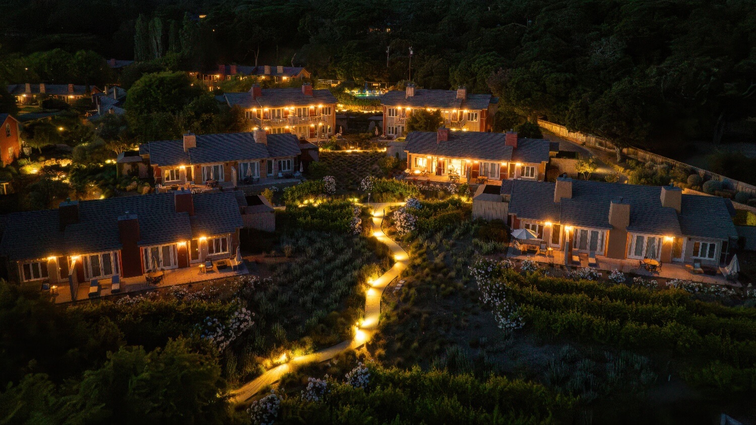 Night aerial of lit villas and a lantern-lined garden path at Bernardus Lodge and Spa, Carmel Valley