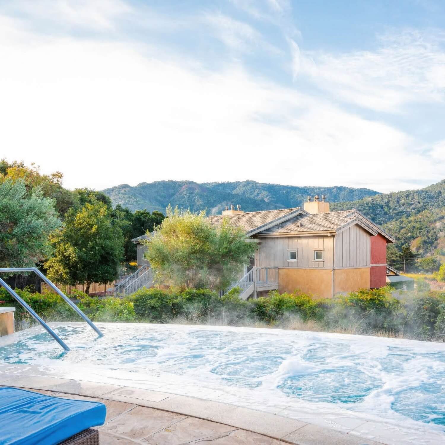 Steaming outdoor whirlpool with villas and Carmel Valley mountains beyond at Bernardus Lodge and Spa, Carmel Valley