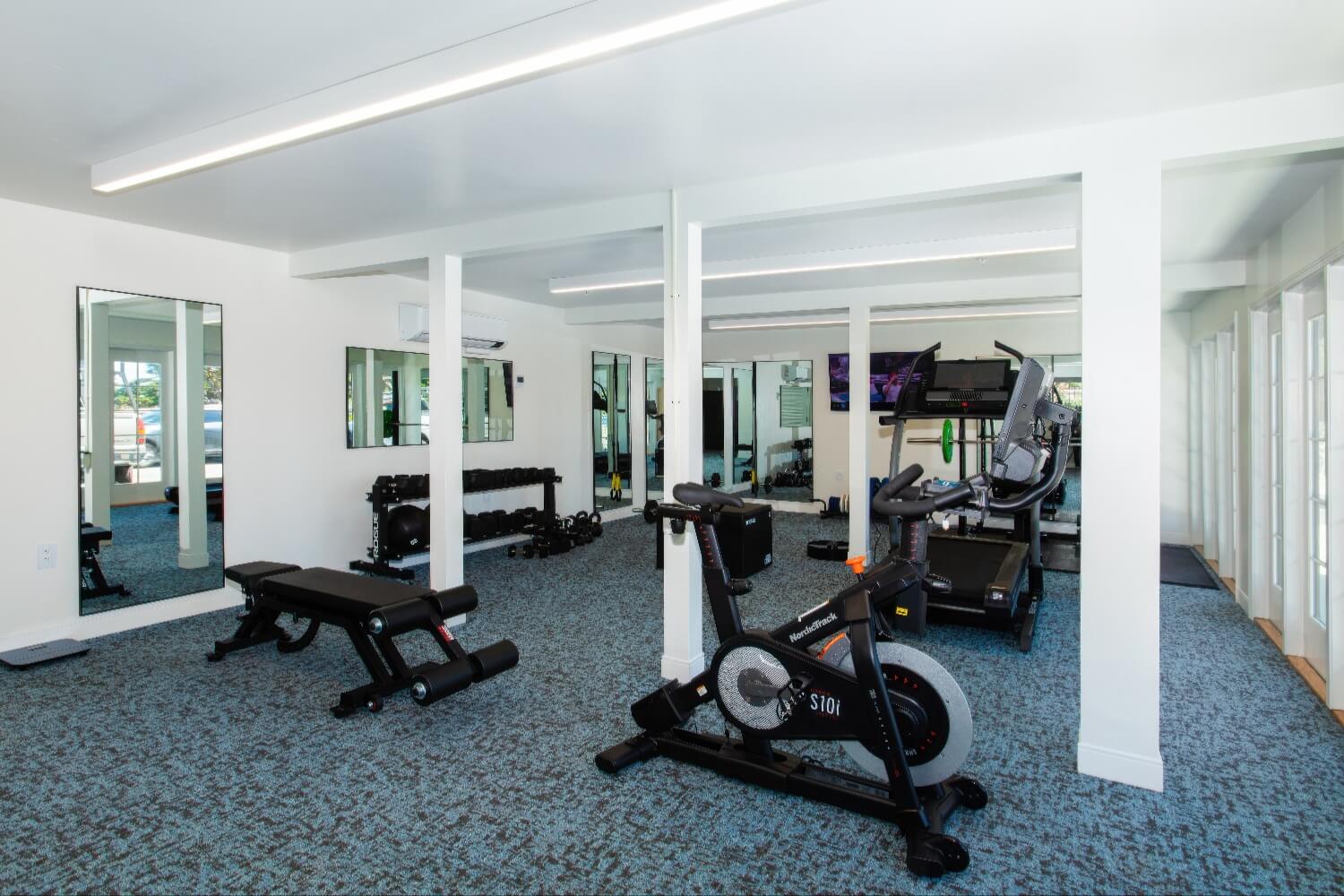 Fitness studio with spin bike, treadmill, free weights and mirrored walls at Carmel Beach Hotel, Carmel-by-the-Sea