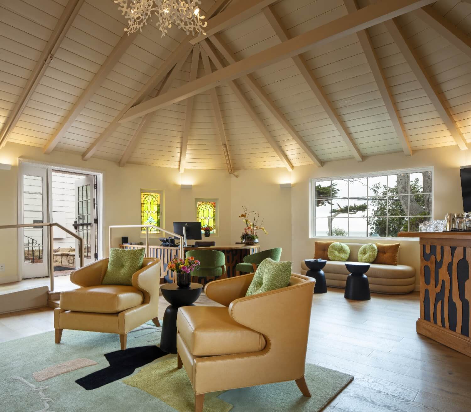 Lobby lounge with vaulted plank ceiling, stained glass windows and leather armchairs at Carmel Beach Hotel, Carmel-by-the-Sea