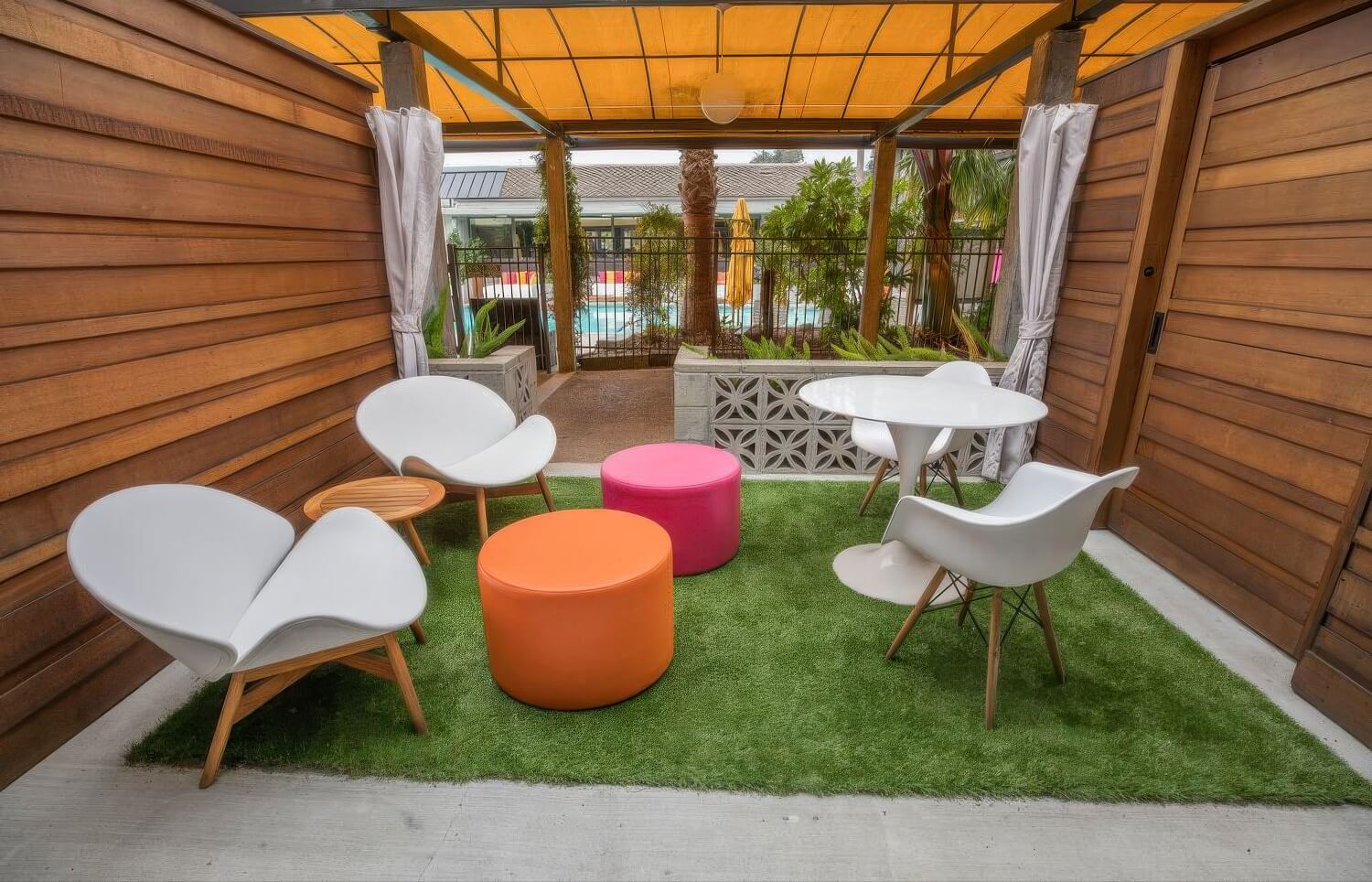 Private poolside cabana with turf floor, white chairs, and a yellow canopy at Carmel Mission Inn, Carmel, California.