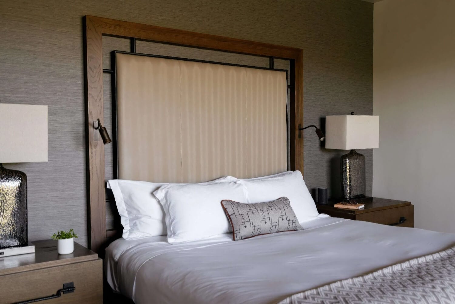 King bed with upholstered headboard in an oak frame and grasscloth walls at Carmel Valley Ranch, Carmel Valley