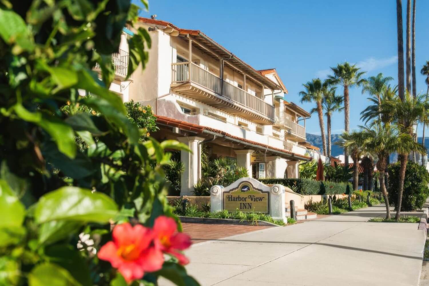 Harbor View Inn entrance sign and balconied Spanish Colonial facade on West Cabrillo Boulevard, Santa Barbara.