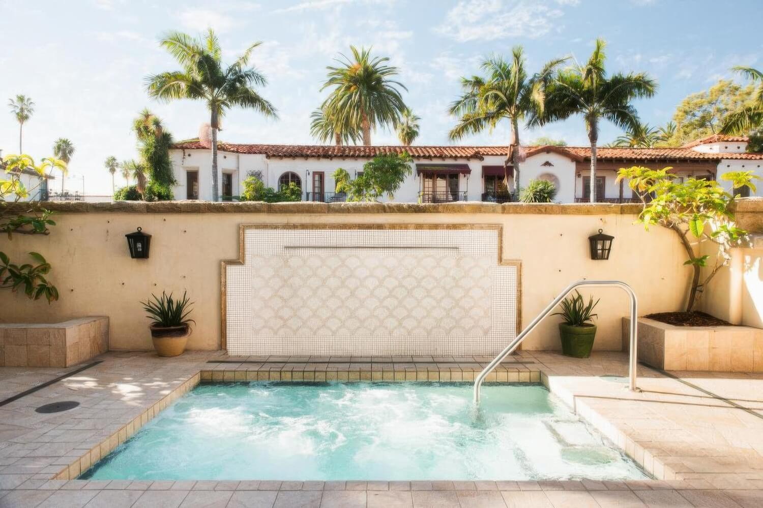 Walled whirlpool courtyard with a scalloped-tile fountain surround at Harbor View Inn, Santa Barbara.