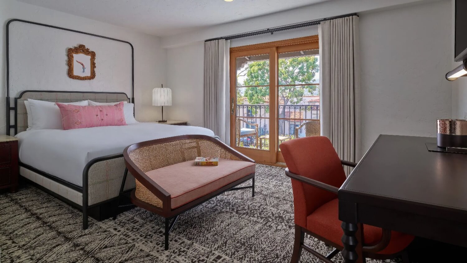 King guest room with sliding doors to a small balcony and a writing desk at Mar Monte Hotel, Santa Barbara.