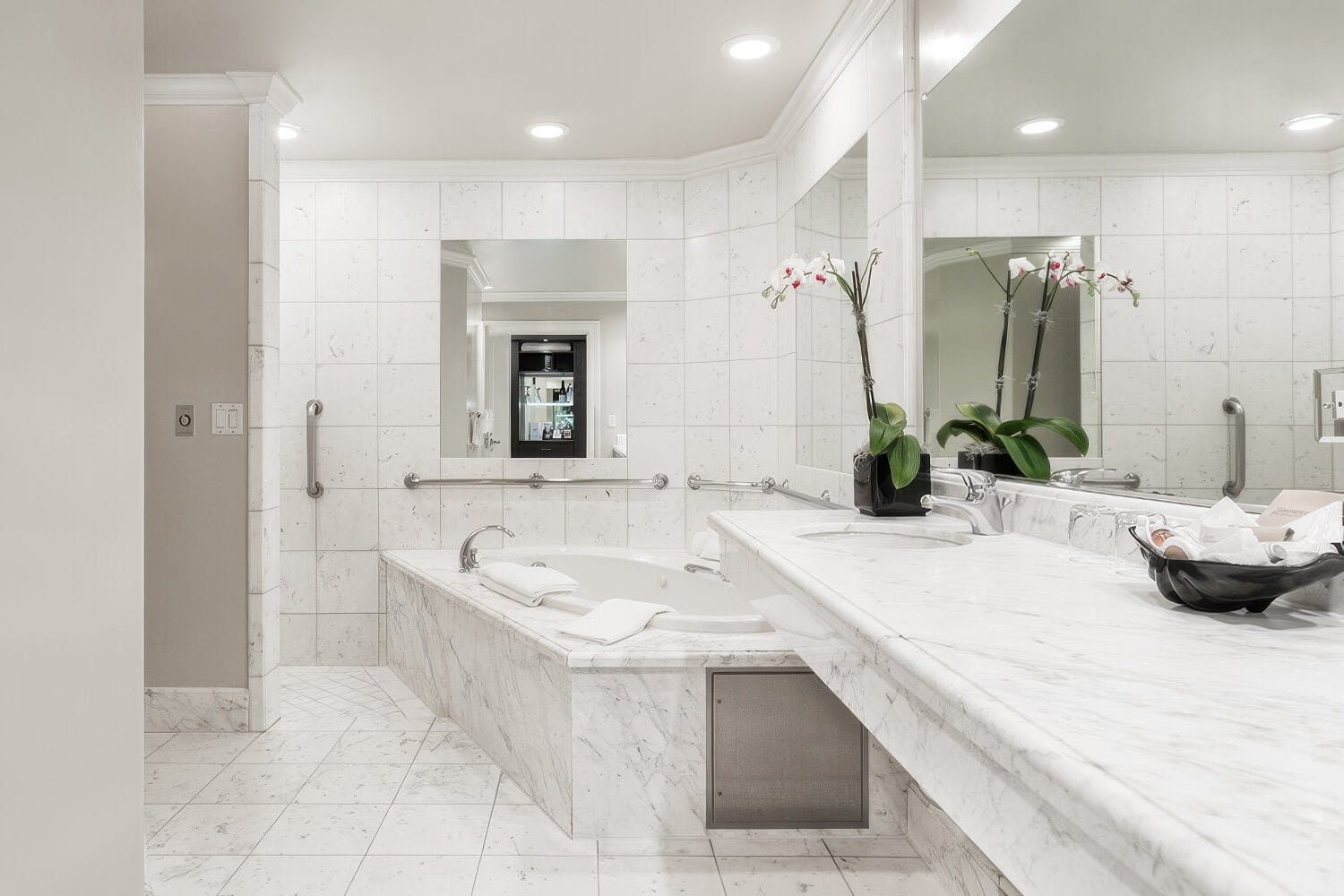 Marble bathroom with soaking tub, double vanity and mirrored walls at the Montecito Inn, Montecito