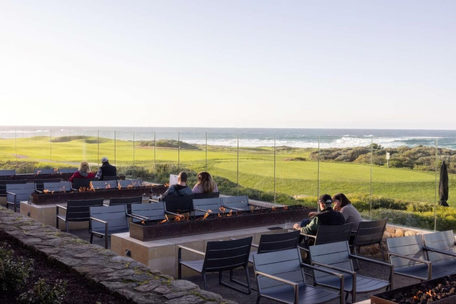 Gas fire pits behind glass windscreens overlooking links and surf at The Inn at Spanish Bay, Pebble Beach