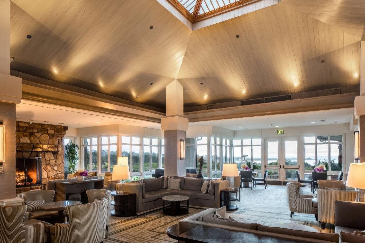 Vaulted lobby with skylight, stone fireplace and ocean-view windows at The Inn at Spanish Bay, Pebble Beach